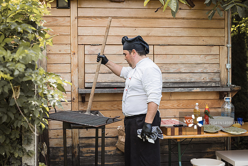 厨师用煤和铲子点燃烤架图片素材