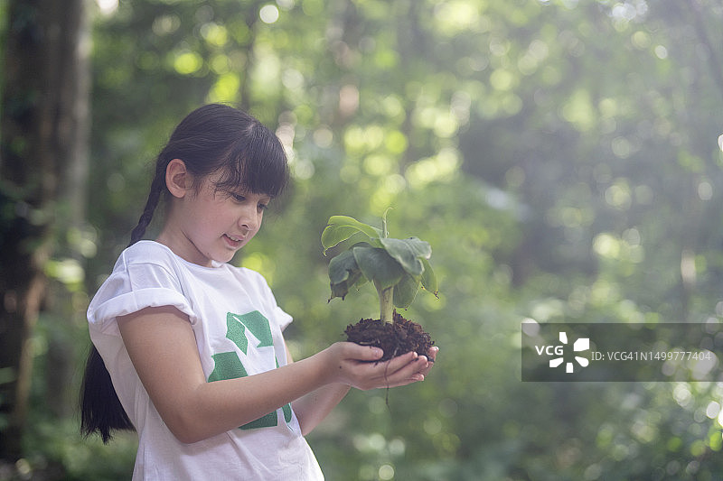 西班牙女孩在地球日保护花园中的小植物图片素材
