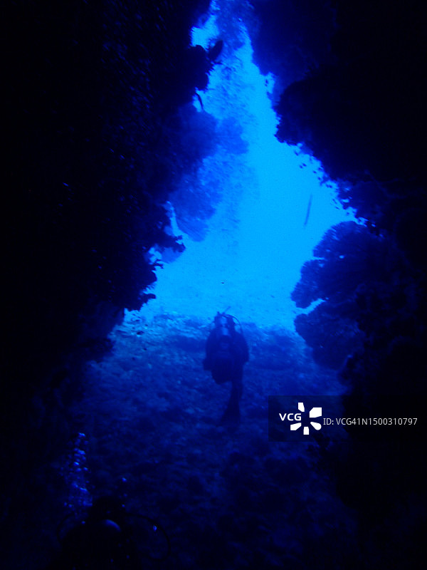 戴水肺的潜水员游出了洞穴图片素材