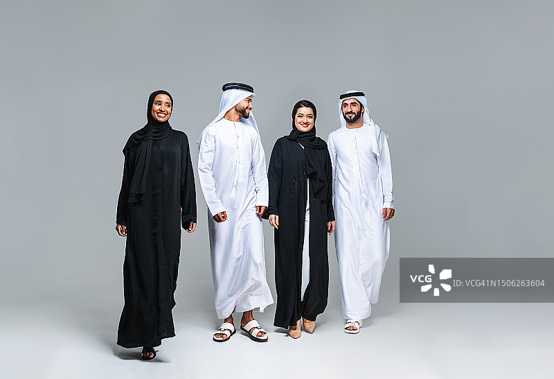 阿拉伯联合酋长国，身着传统中东服装的多民族人群微笑着站在白色背景的地板上图片素材