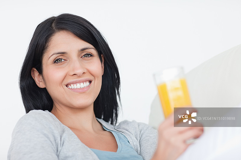 微笑的女人拿着一杯果汁图片素材