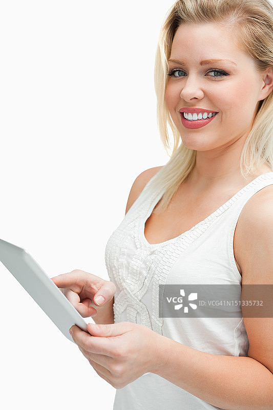 快乐的金发女人触摸着她的平板电脑图片素材