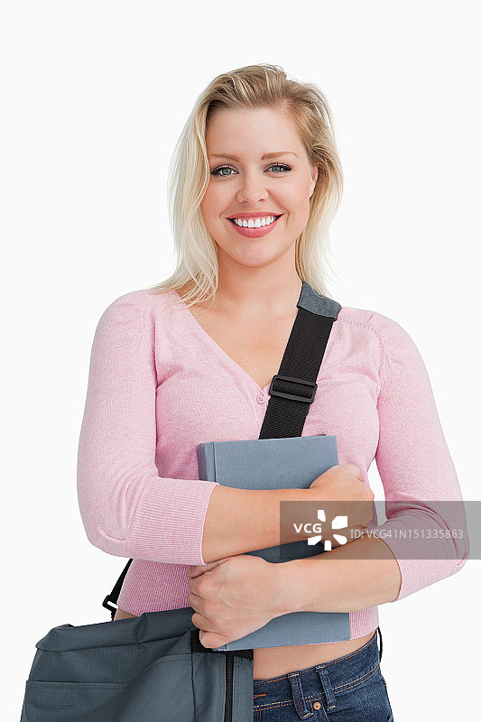 快乐的金发女人拿着一本教科书图片素材