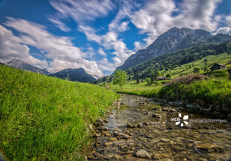 风景秀丽的河流在山对天空，瑞士图片素材