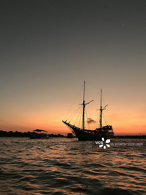 日落时帆船在海上逆天航行的剪影图片素材