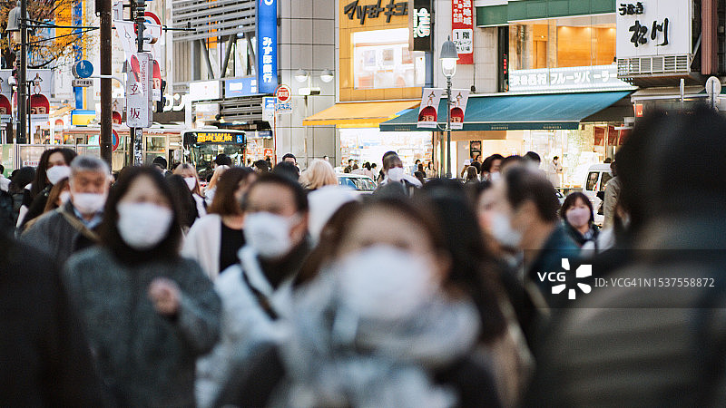 一群日本人、亚洲人、游客在东京涩谷的十字路口行走。日本旅游景点，旅游地标，亚洲交通城市生活理念图片素材