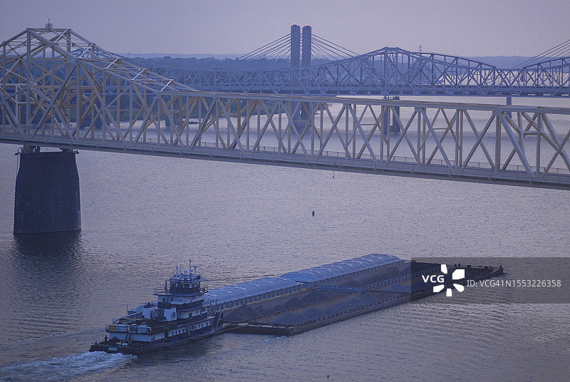 一艘驳船在肯塔基州路易斯维尔的俄亥俄河上运输原材料图片素材