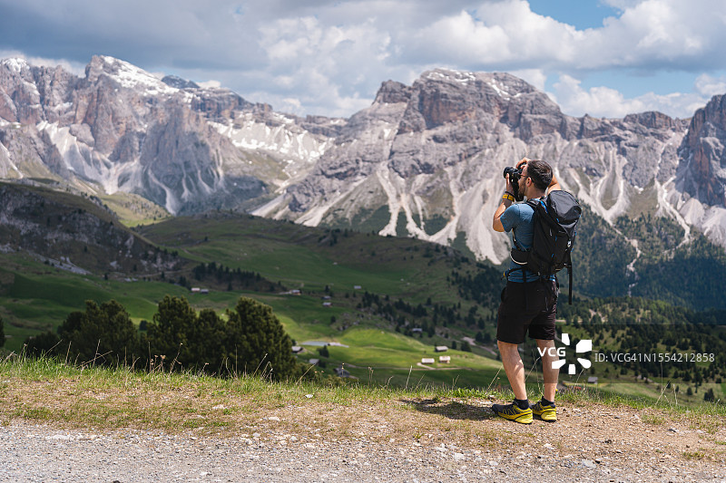 男性高加索徒步旅行者，拿着相机在塞塞达山脉拍照图片素材