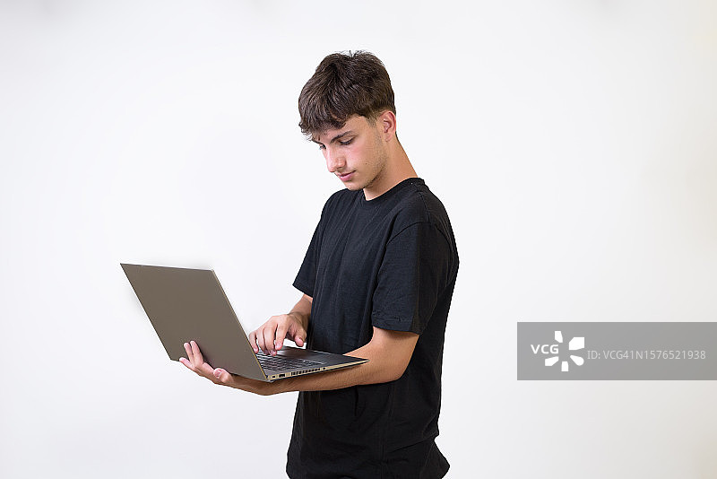 年轻人站在白色背景下使用笔记本电脑图片素材