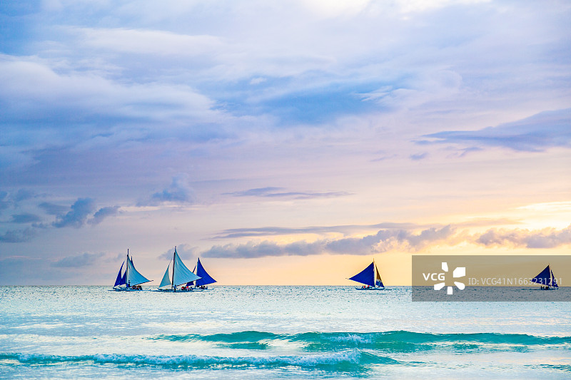 长滩岛附近平静的苏禄海上的帆船。日落的场景。图片素材