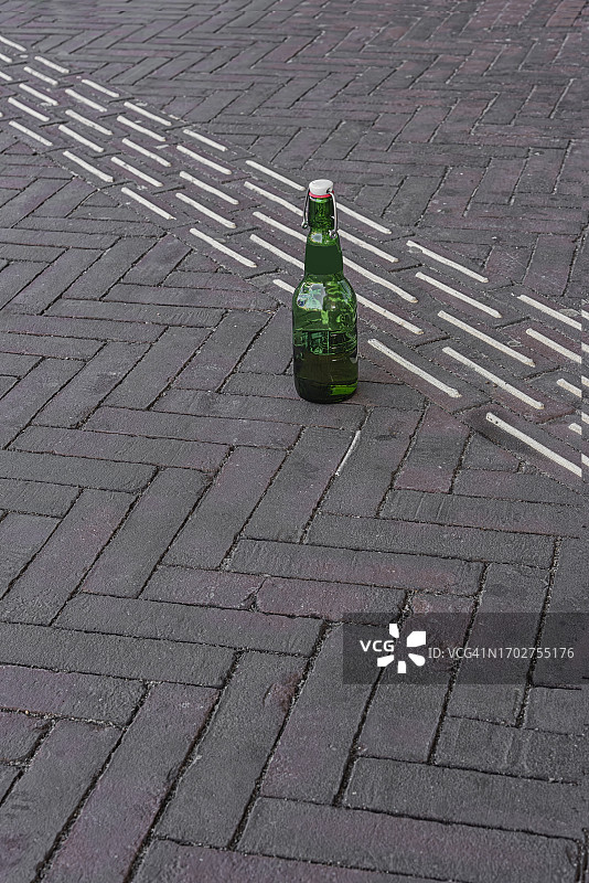 外面街上有一个白色瓶盖的绿色啤酒瓶图片素材