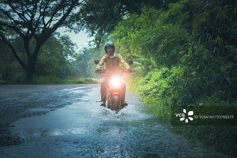 骑摩托车的女人在树林里的路上图片素材