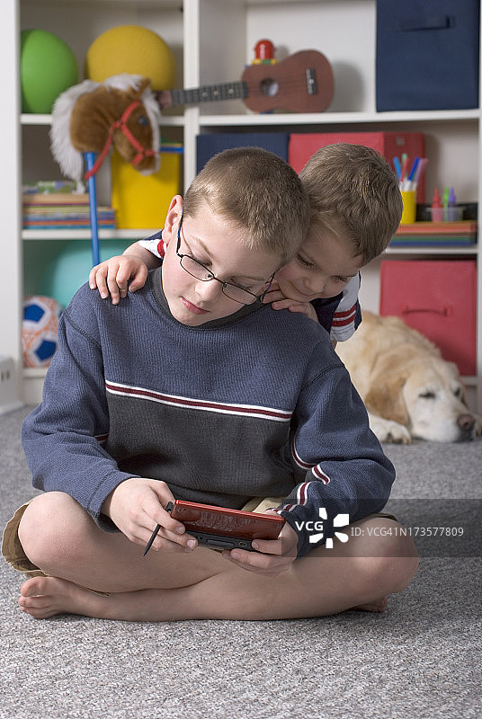 男孩和哥哥和狗玩电子游戏图片素材