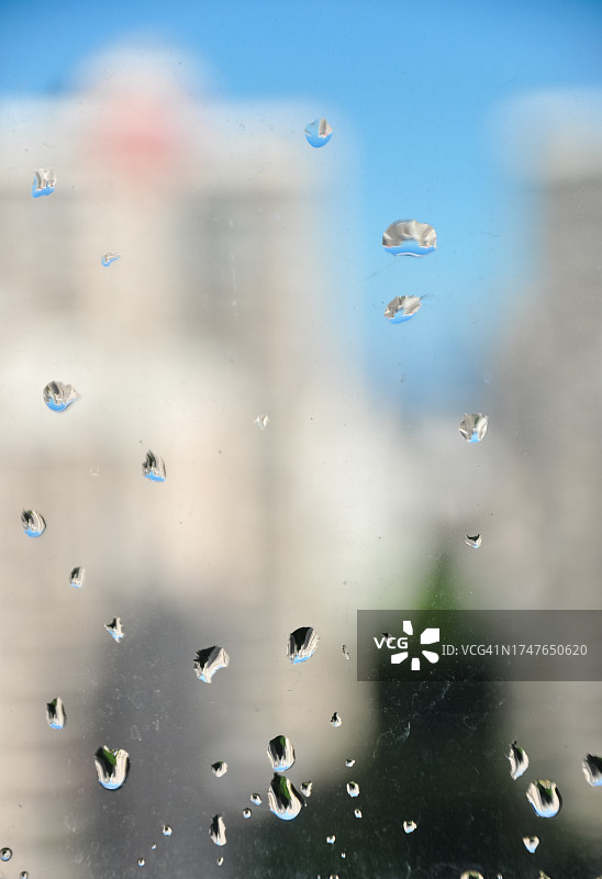 雨滴落在透明的玻璃窗上。平面设计的概念背景。图片素材