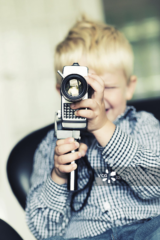 男孩用一台复古相机拍视频图片素材