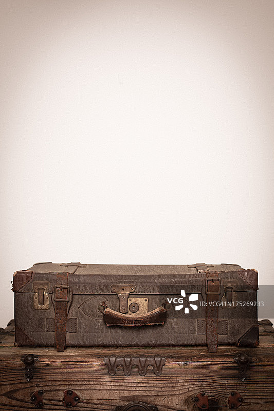 复古行李箱坐在木箱上，有拷贝空间图片素材