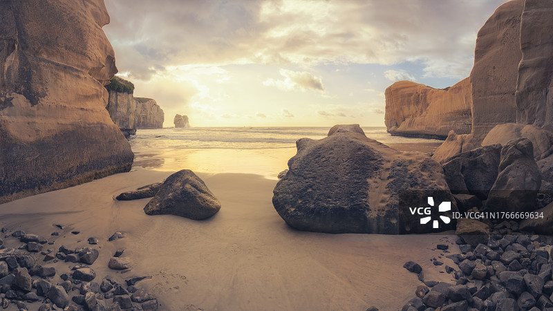新西兰南岛，日出时岩石砂岩海岸线和入口图片素材