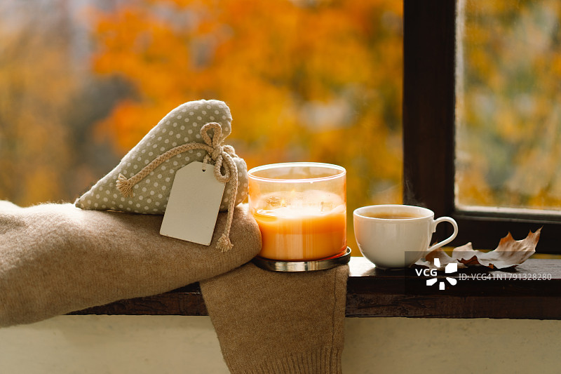 毛衣、蜡烛、热咖啡和秋天的装饰。秋季家居装饰图片素材