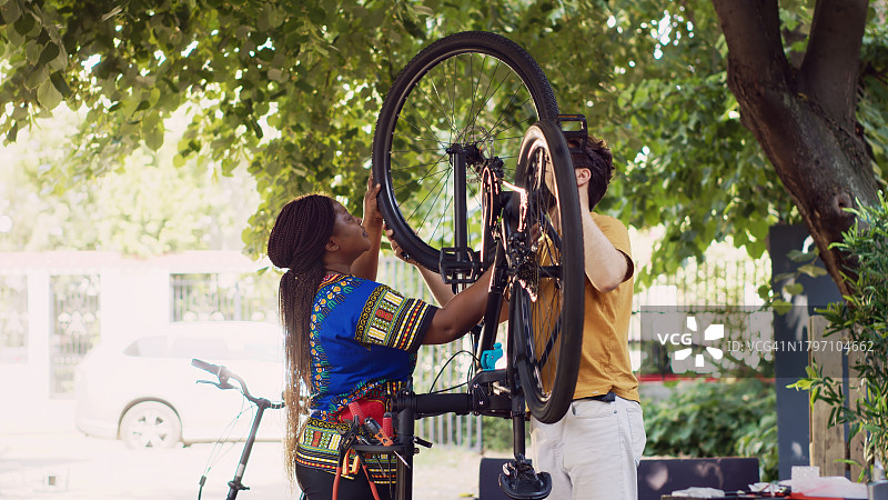 多民族夫妇系自行车车轮图片素材