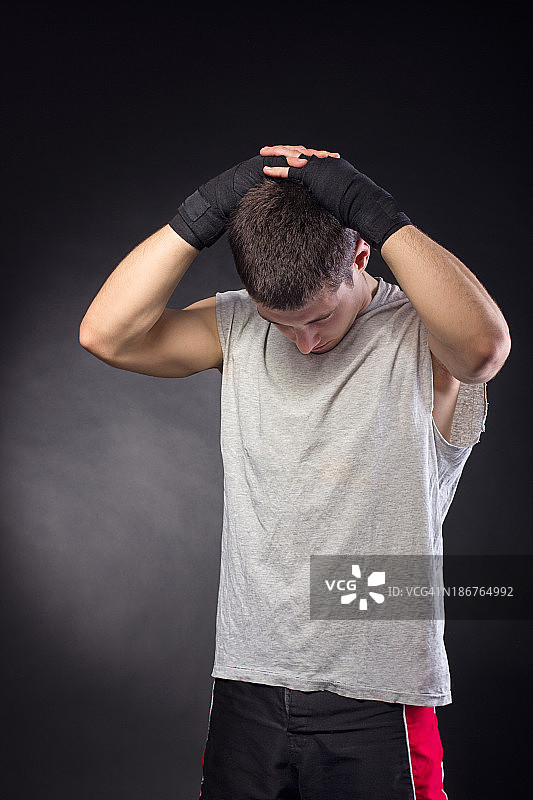 英俊的男拳击手，带着绷带，伸展身体图片素材