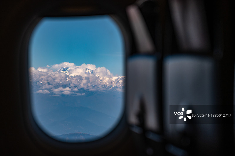 在飞行中透过飞机的窗户可以看到珠穆朗玛峰。图片素材