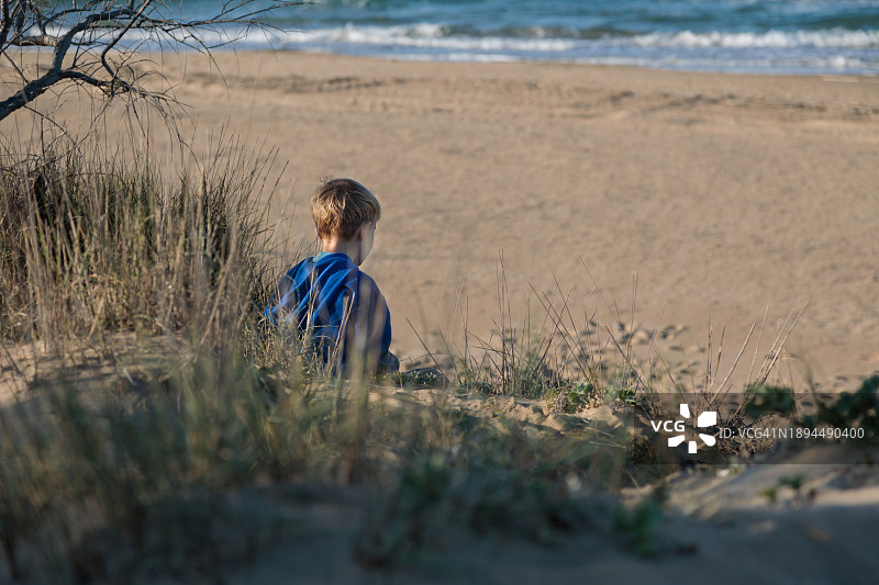 小男孩坐在沙滩上图片素材