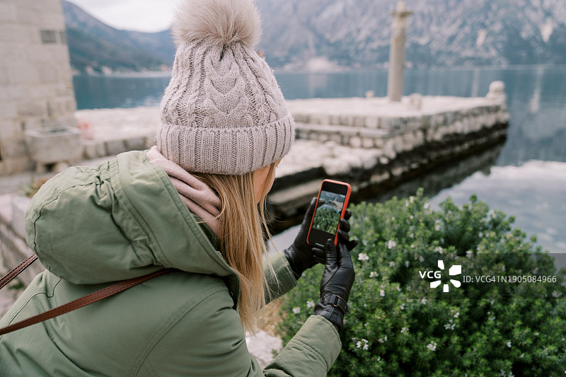女子用手机拍摄湖泊图片素材