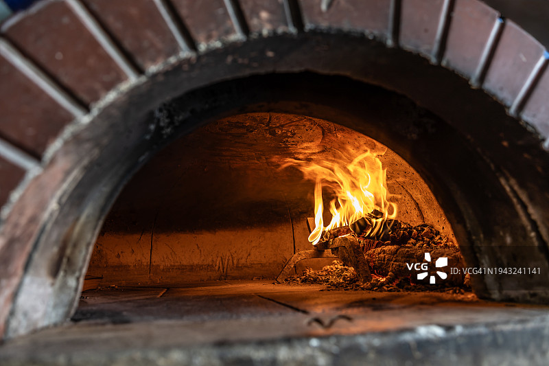 砖砌披萨烤箱，用燃烧的木头生火烘烤。图片素材