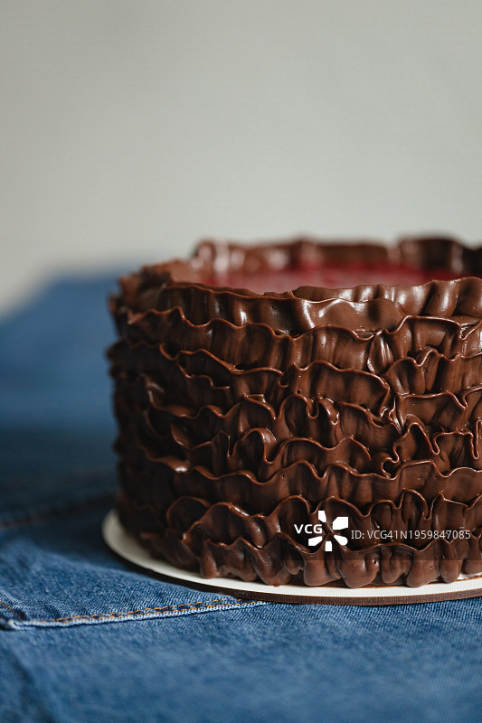 牛仔桌布上的巧克力蛋糕。图片素材