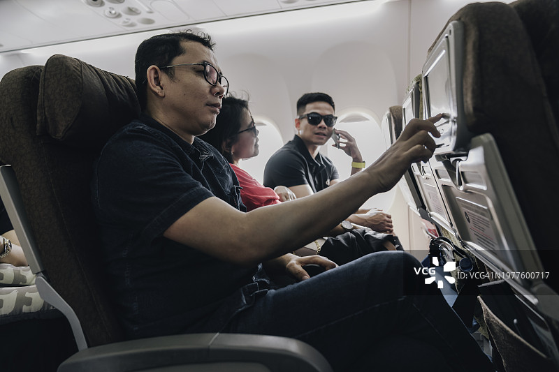 团体旅客在飞机上使用机上娱乐设施图片素材