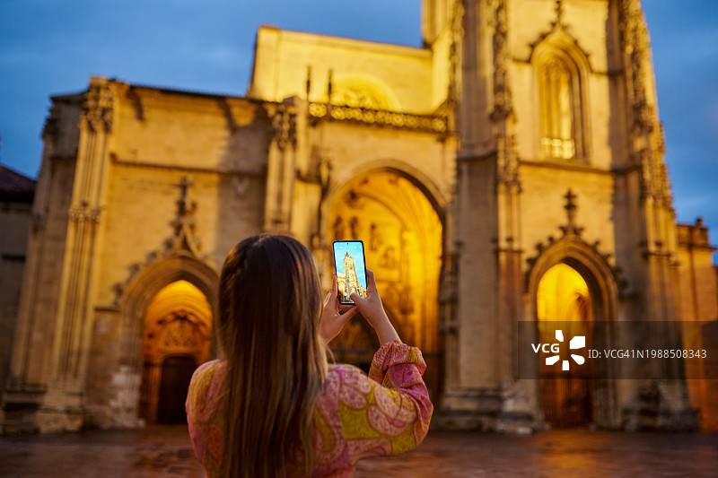 女人，手机和教堂建筑或建筑的照片作为游客探索城市，地标或尊重。女性的人，背后和夕阳为宗教大教堂或冒险，旅游或意大利图片素材