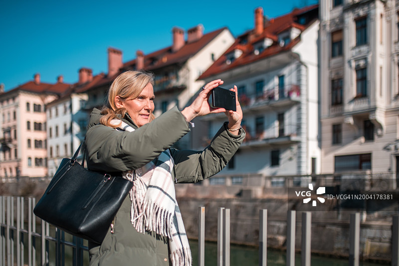 成熟的白人女性游客在市区拍照图片素材