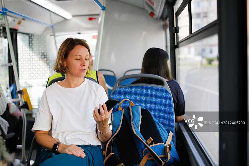 精通科技的通勤者:用智能手机导航城市交通的中年妇女图片素材