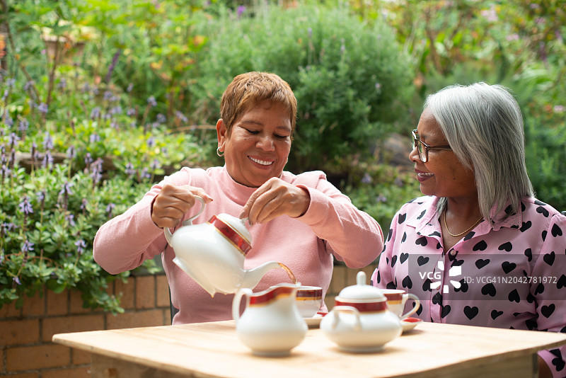 老年人、妇女和朋友在家中的花园户外喝茶，在后院放松和闲聊。老年人、人们在大自然中与热饮结缘、谈笑风生图片素材