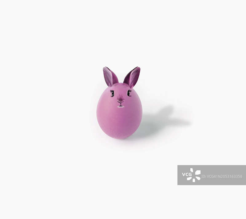 复活节快乐，有兔子耳朵、眼睛和嘴部的粉色彩蛋。复活节贺卡。图片素材