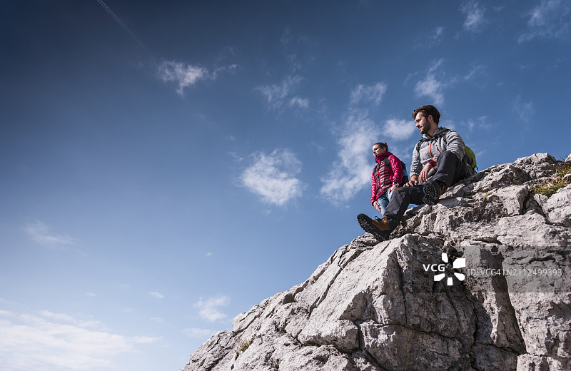 巴伐利亚阿尔卑斯山的山峰上，男子坐在女友身旁图片素材