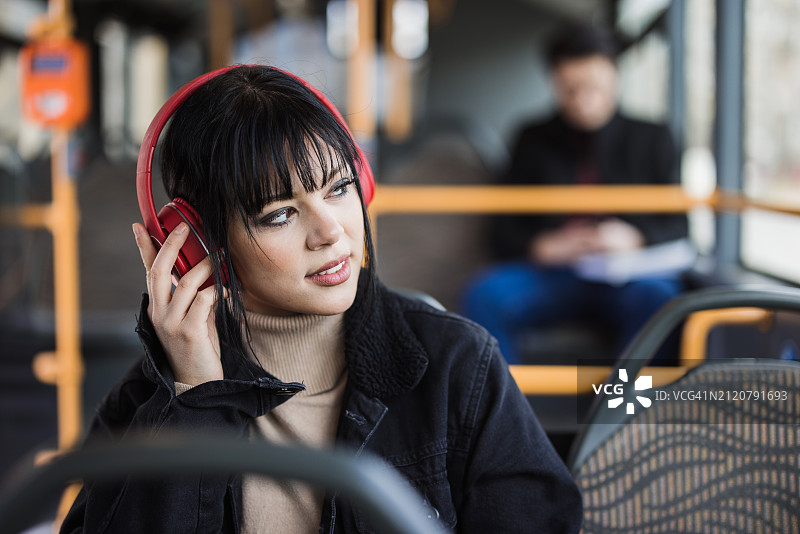 一名女子在公交车上用无线耳机听音乐图片素材