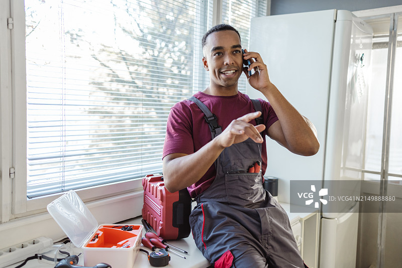 一个年轻的非裔美国勤杂工正在打电话图片素材