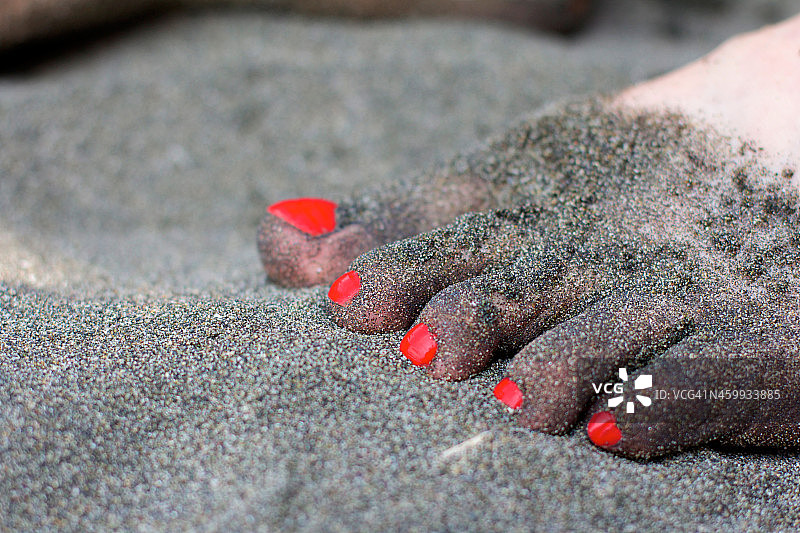 一个女人把脚踩在沙子上图片素材