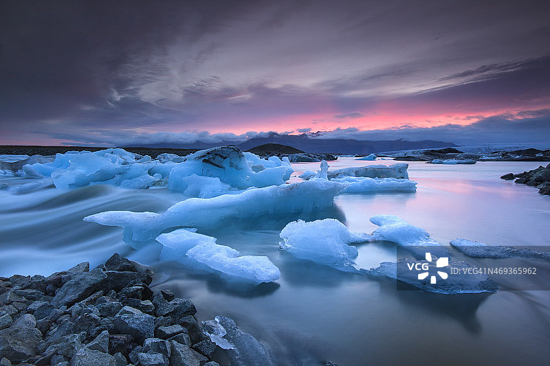 日落时冰山漂浮在Jokulsarlon冰川湖上图片素材