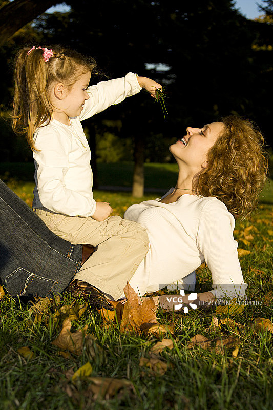 母亲和女儿在秋天的公园图片素材