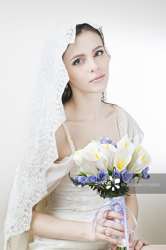 年轻美丽的新娘捧着婚礼花束图片素材