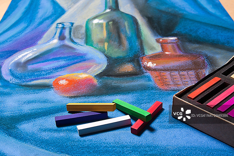画家用彩色粉笔和原始彩色粉笔画静物。图片素材