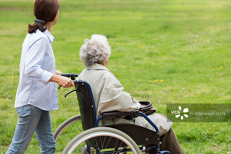 生活照顾者和坐在轮椅上的老年妇女图片素材