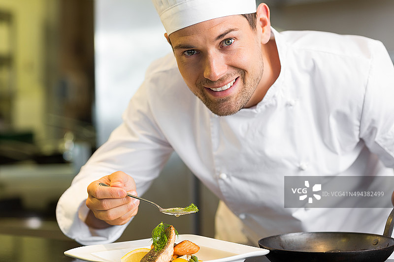 微笑的男厨师在厨房装饰食物图片素材