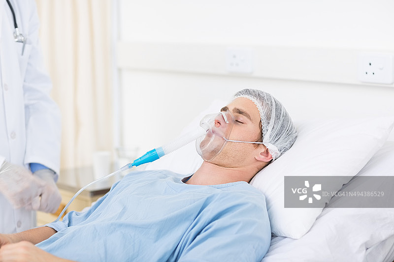 男医生调整病人的氧气面罩图片素材