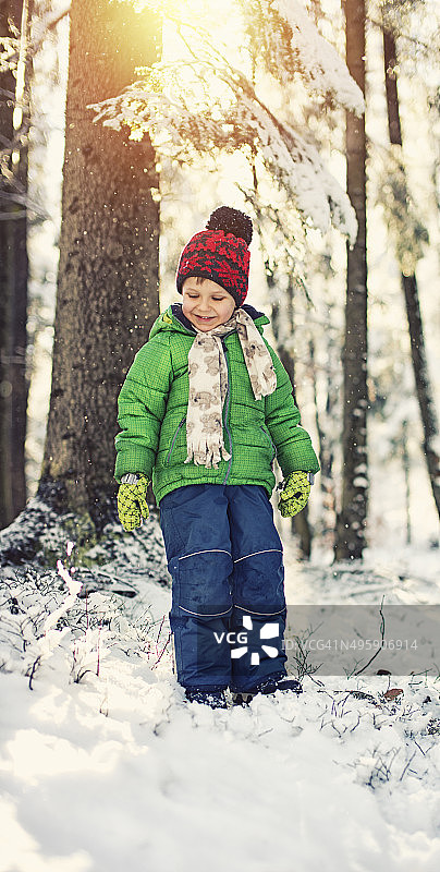 小男孩在冬天的森林里图片素材