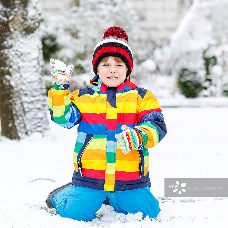 小男孩冬天在户外玩雪。图片素材