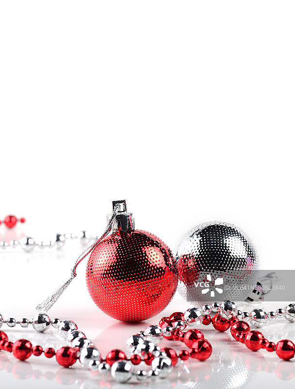 红色和银色圣诞球与装饰品在白色的背景。图片素材