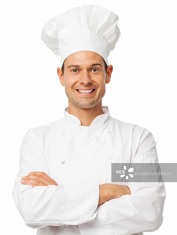 微笑的厨师穿着制服，双臂交叉站着图片素材
